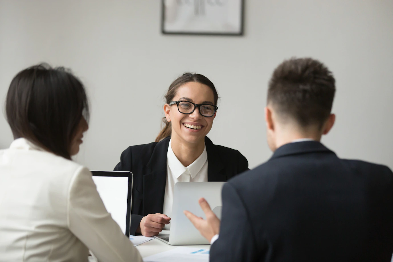 smiling-businesswoman-talking-with-subordinated-about-reports_1163-4665